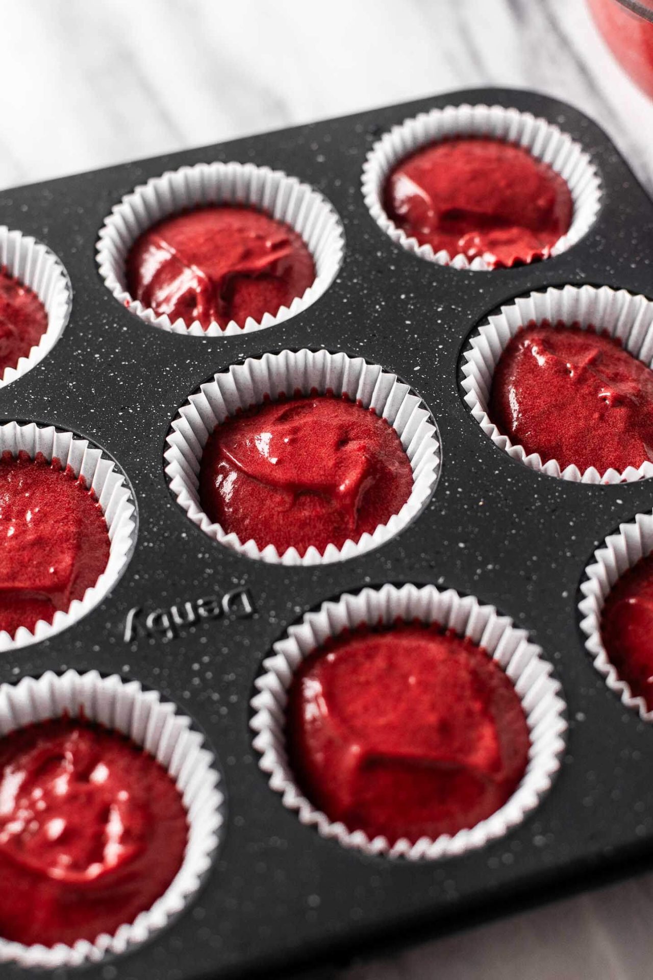 red velvet cupcake batter portioned into cupcake tin-1