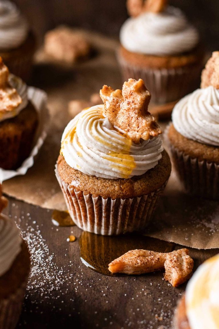 frosted maple cupcakes decorated with leaf shaped pie crust on tabletop
