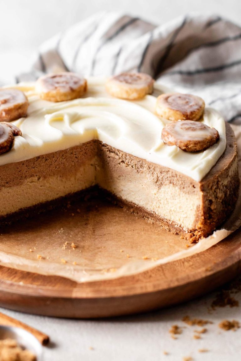 sliced cinnamon roll cheesecake on wooden serving plate