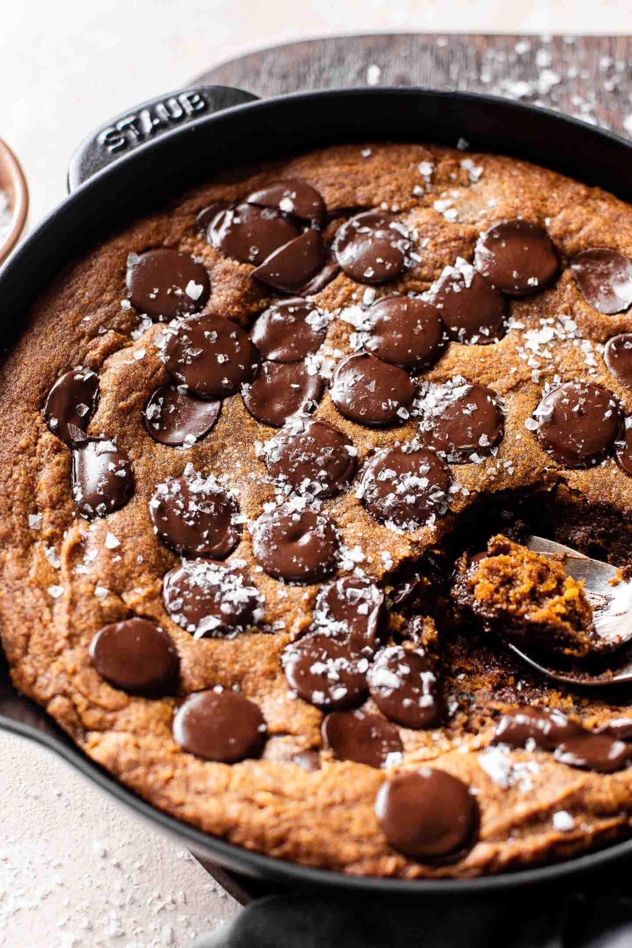 giant pumpkin chocolate chip cookie skillet with spoons scooping a piece out