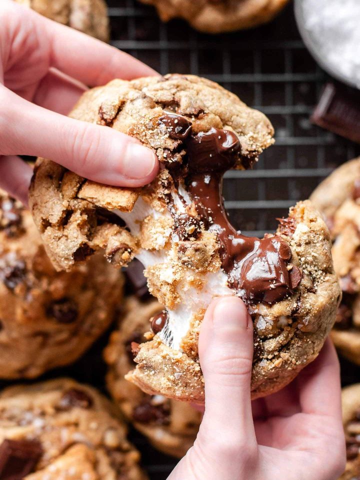 s'mores chocolate chip cookie being pulled apart revealing gooey marshmallow and chocolate inside