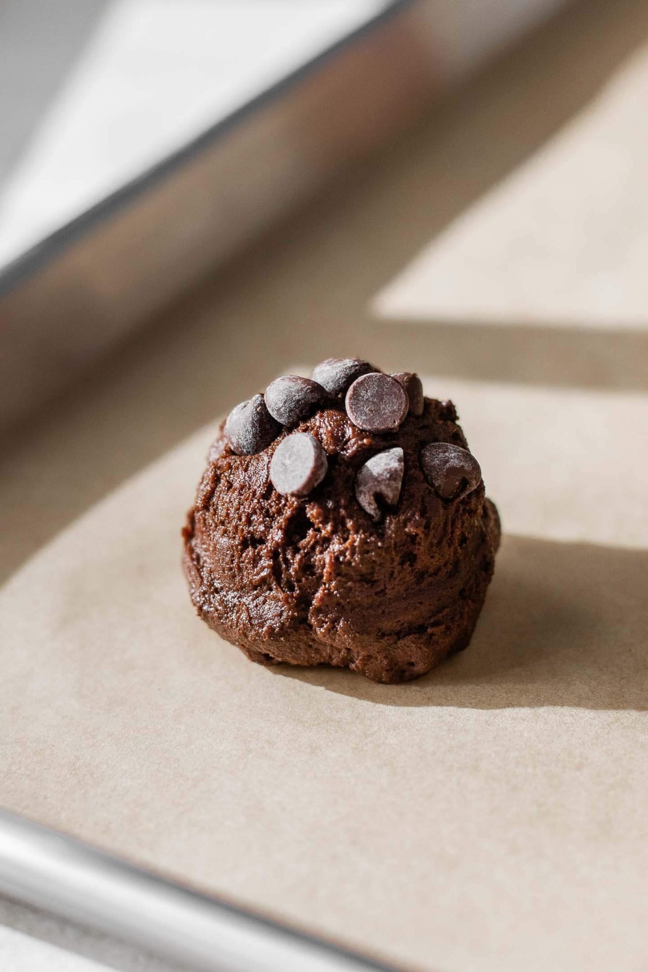 scoop of double chocolate chip cookie on parchment lined wire rack