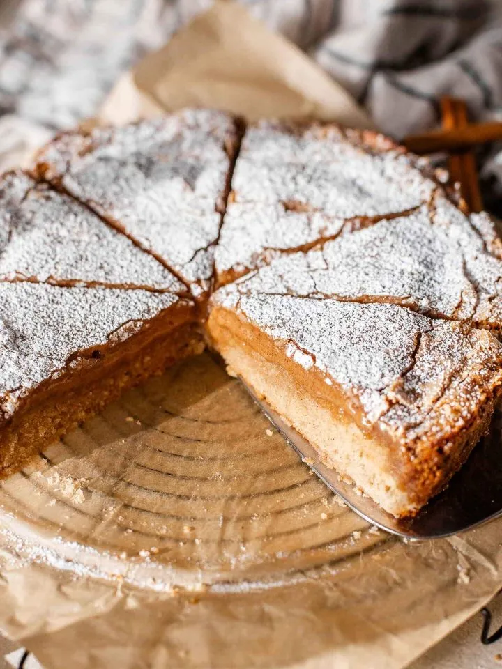 sliced cinnamon roll gooey butter cake on parchment lined wire rack overhead view
