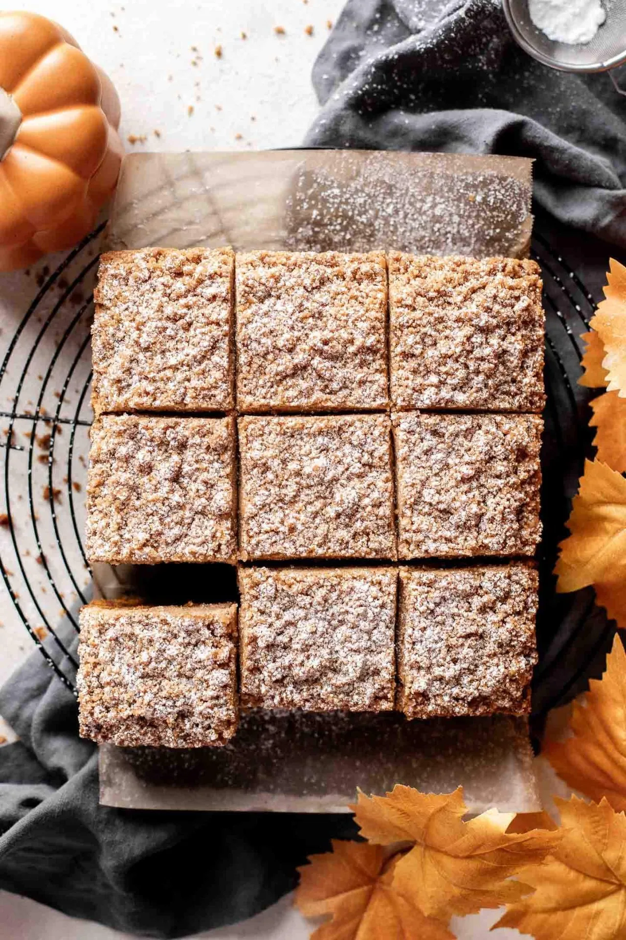 sliced pumpkin coffee cake on parchment lined wire rack overhead image