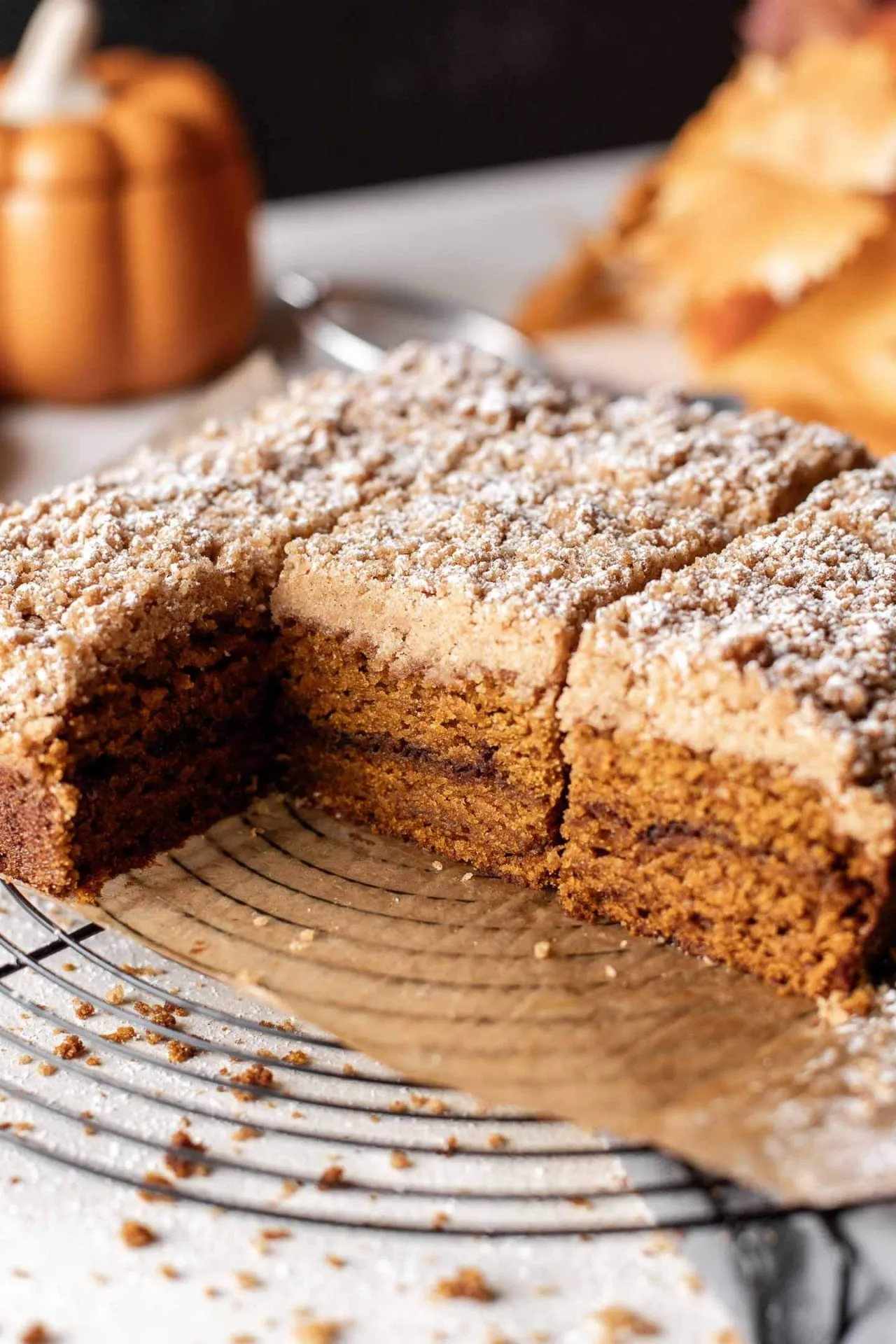 sliced pumpkin coffee cake on parchment lined wire rack